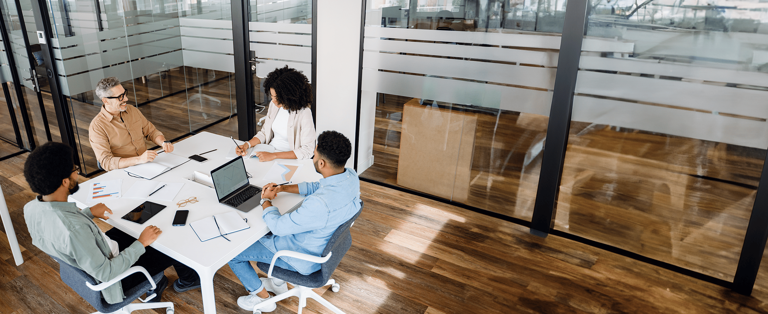 Three business people in a meeting discussing advantages for a grenke Partner and offering equipment finance and leasing solutions