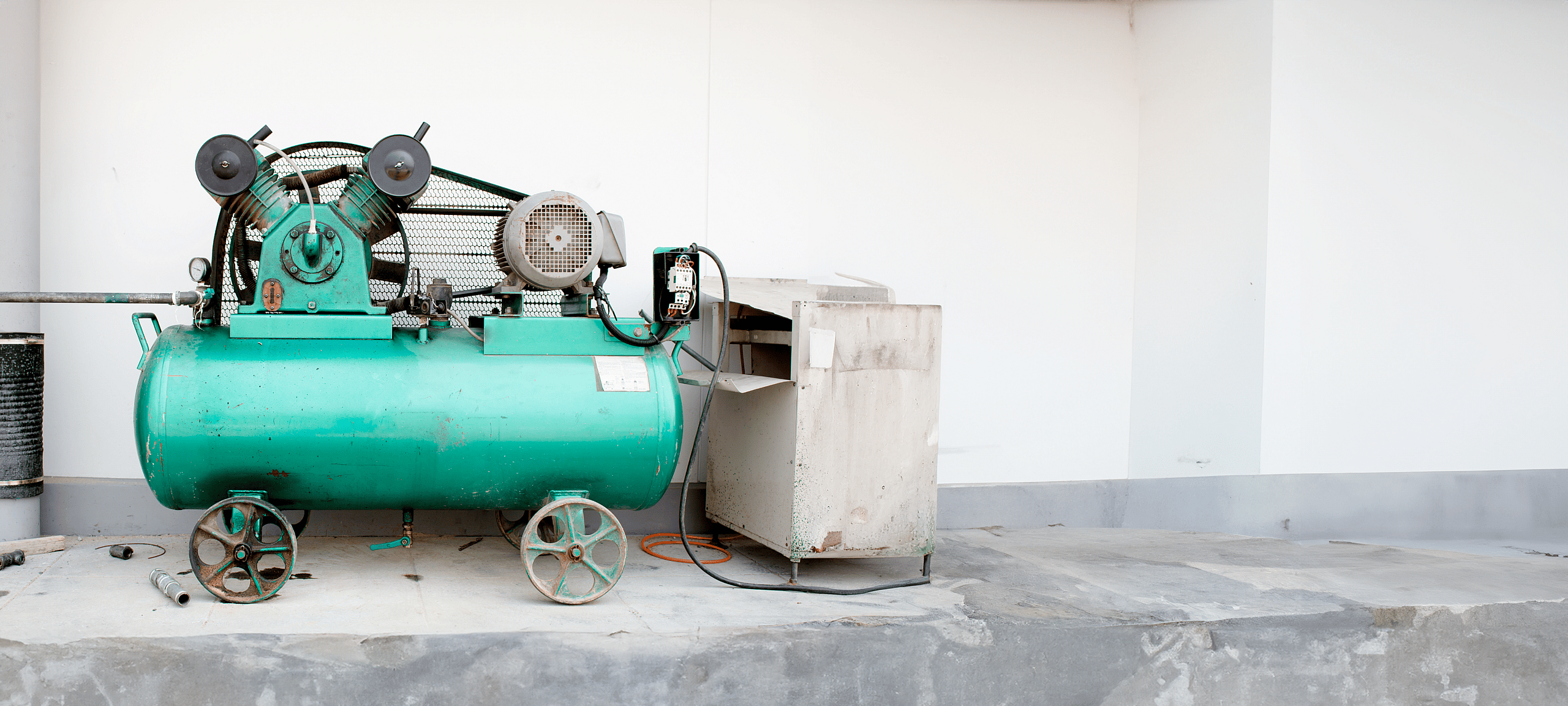 Turquoise air compressor with grenke's flexible financing options for rotary screw, reciprocating, and portable compressors. Ideal for industrial and construction use.