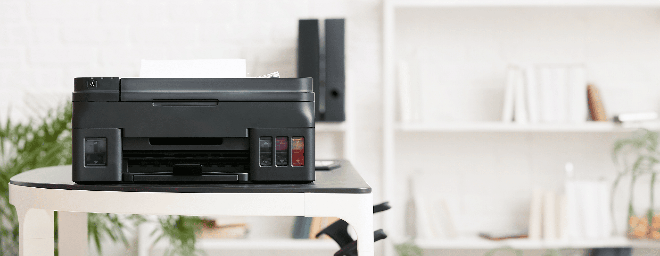 Black printer on a table in an office environment, showcasing grenke's flexible leasing options for laser, LED, multifunction, and 3D printers, helping businesses stay connected and competitive with strategic financing solutions.