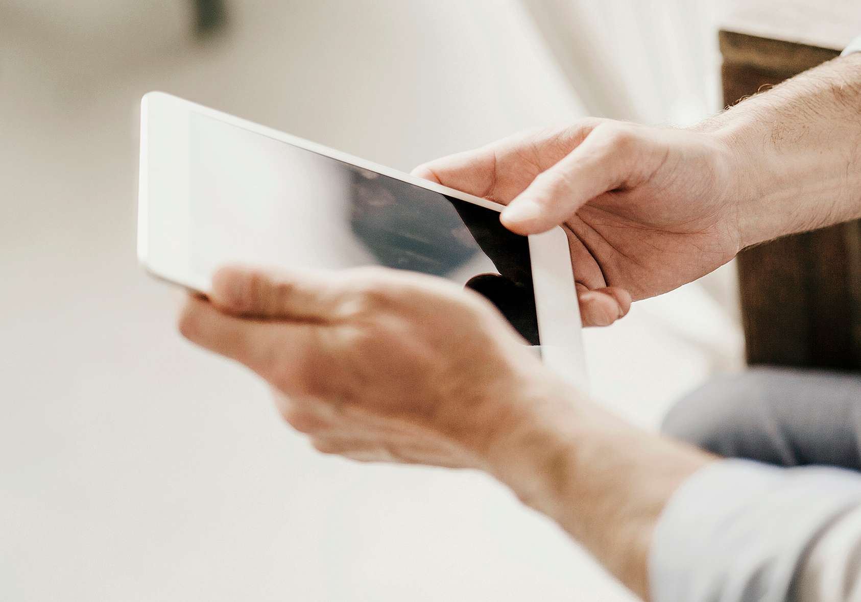 Person using iPad for payments and invoicing management on grenke Customer Care page.