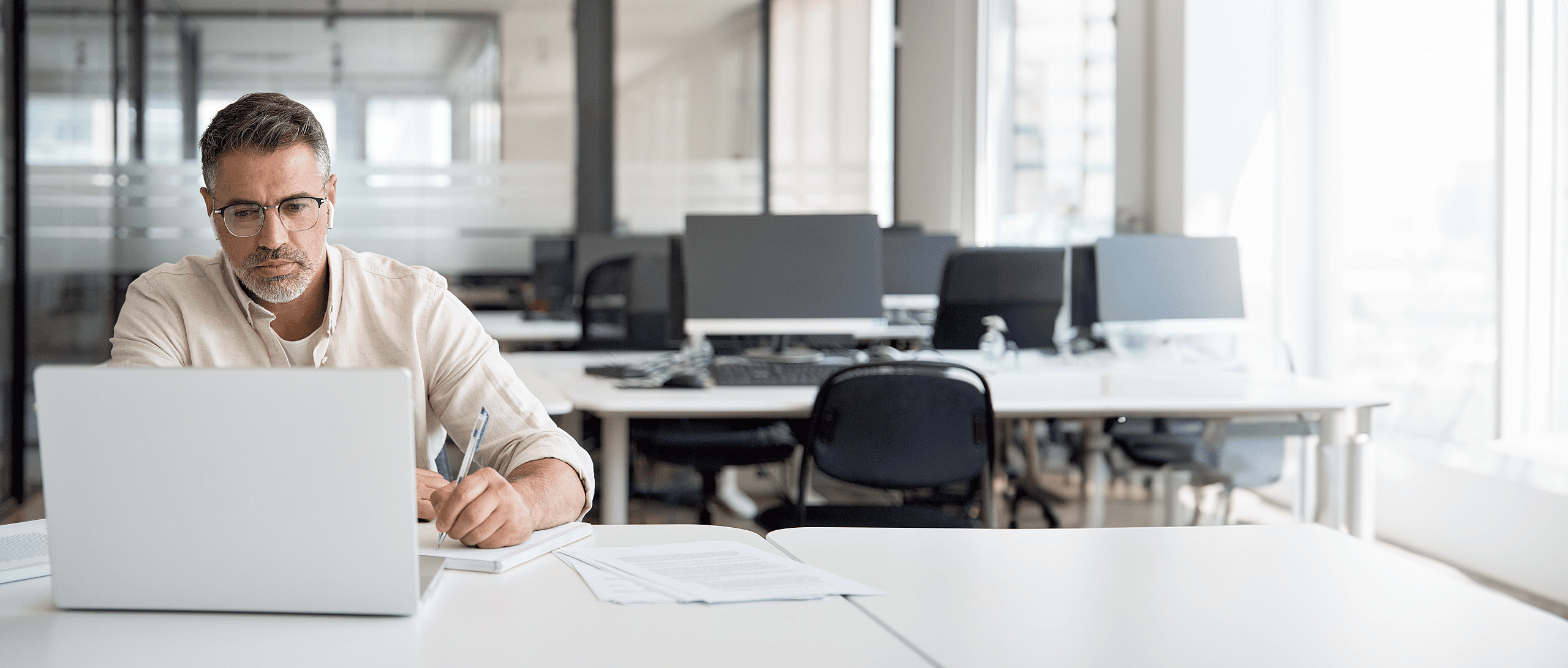 Focused man sitting by his laptop in an office, representing grenke UK's focus on responsible corporate governance and compliance.