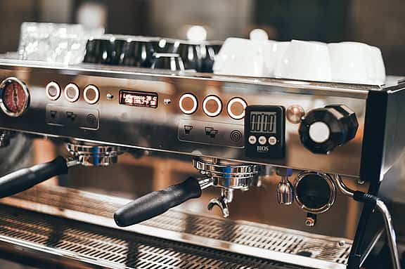 Close-up of a professional barista coffee machine in a hospitality establishment, illustrating grenke's financing options for single-serve brewers, commercial espresso machines, and quality coffee equipment.