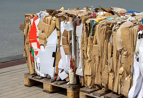 Compressed cardboard boxes, highlighting grenke's financing solutions for waste management equipment, including compactors, balers, sorting, and screen machinery, to promote efficient and eco-friendly waste handling practices.