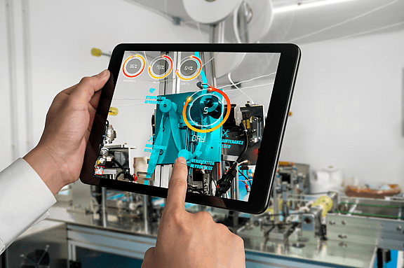 Close-up of hands using an iPad with productivity software in a factory setting, demonstrating grenke's financing options for industry-specific software, productivity tools, and security programs.