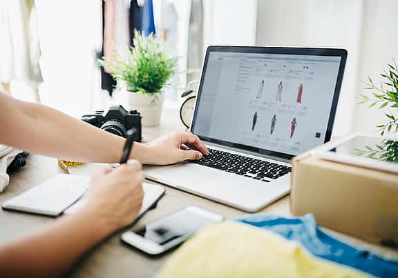 Person using laptop and notebook for tracking payment schedules on grenke Customer Care page