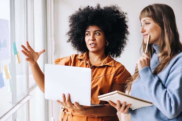 Two business people in a corporate building, discussing sales without boundaries with tailored leasing finance and supplier support by grenke.