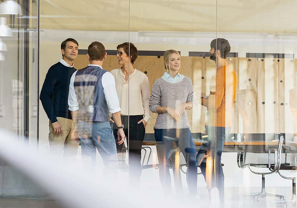 Networking in a modern office, symbolizing grenke UK's dedication to fostering business relationships through LCCI membership.