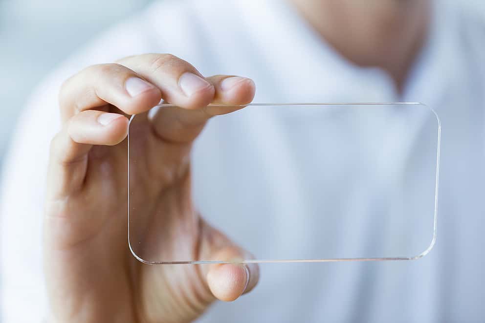 Businessman holding a transparent object, symbolizing grenke UK's commitment to transparent practices and clear reporting.